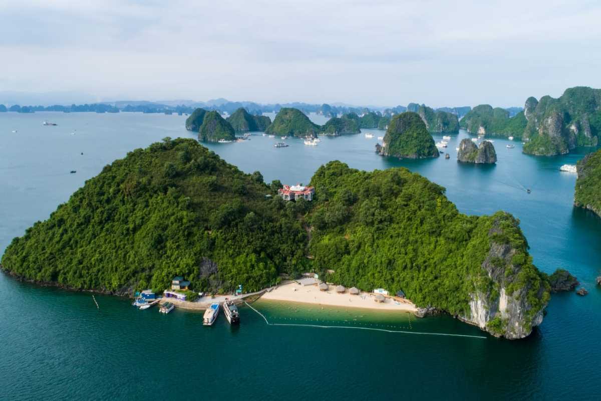 Soi Sim Island Halong Bay sandy beach with loungers and huts Soi Sim Island Halong Bay sandy beach featuring loungers and thatched huts under the shade