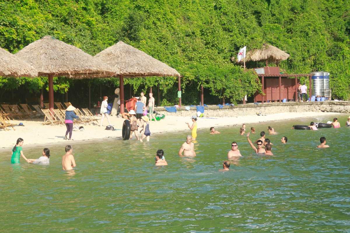 Soi Sim Island Halong Bay Beach Visitors Enjoying Water Visitors enjoying the calm beach and clear water at Soi Sim Island Halong Bay with shaded resting areas
