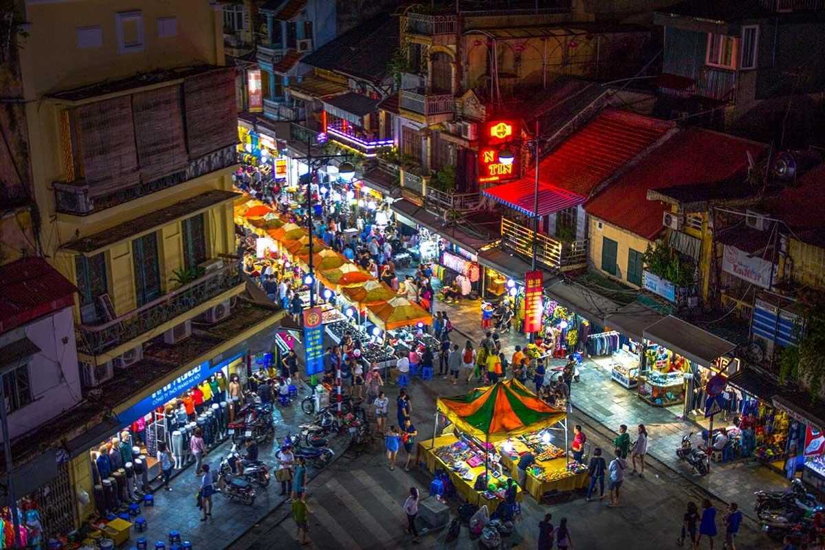 Hanoi Old Quarter street with motorbikes and shops Street view showing motorbikes, shops, and pedestrians in the Hanoi Old Quarter