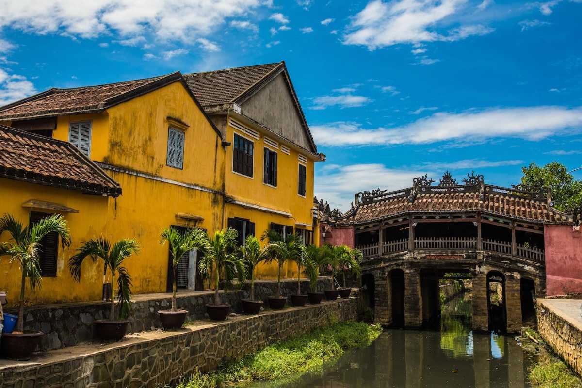Vibrant Street Scene Adjacent to Japanese Bridge in Hoi An Busy street with people and shops near the Japanese Bridge Hoi An, showcasing daily local life.
