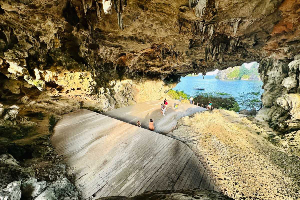 Sunlit wooden pathway inside Drum Cave Halong Bay Wooden walkway bathed in sunlight inside Drum Cave Halong Bay, allowing safe and easy visitor access.