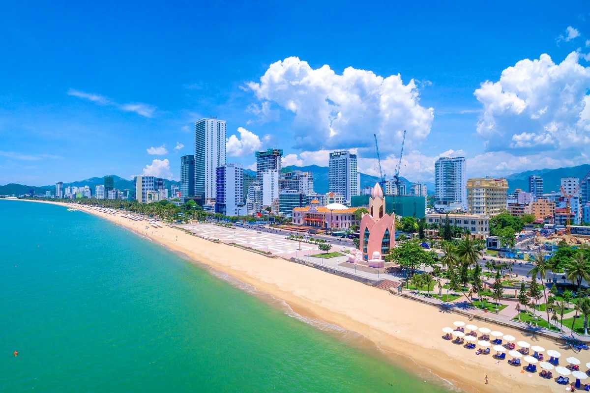 Blue sky beach view of Nha Trang Sunny beach in Nha Trang with clear sky, Lotus Tower and city buildings in the background