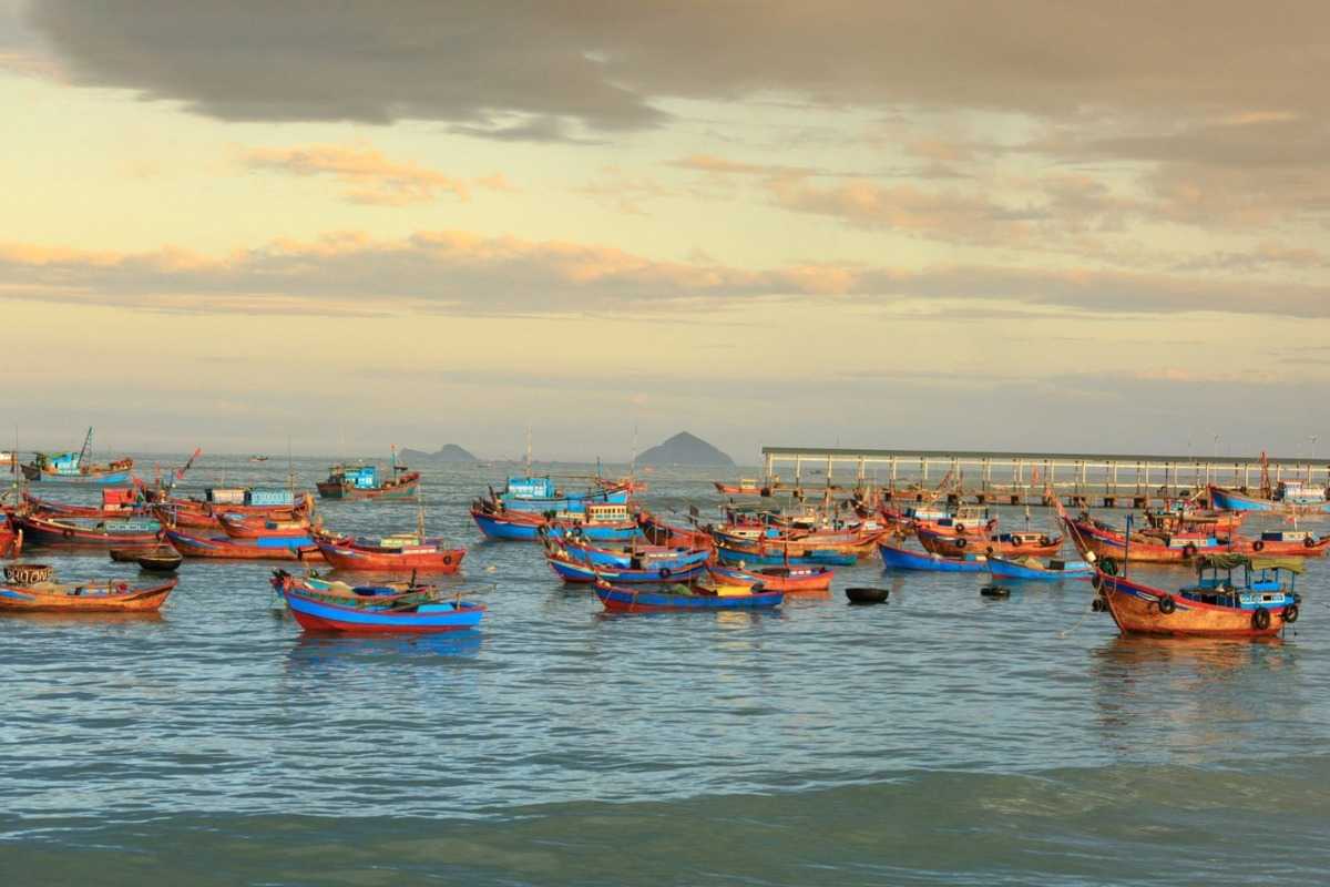 Sunset over Ninh Thuy Fishing Village with fishermen returning to shore Sunset view of fishermen returning to Ninh Thuy Fishing Village shore with basket boats and colorful skies