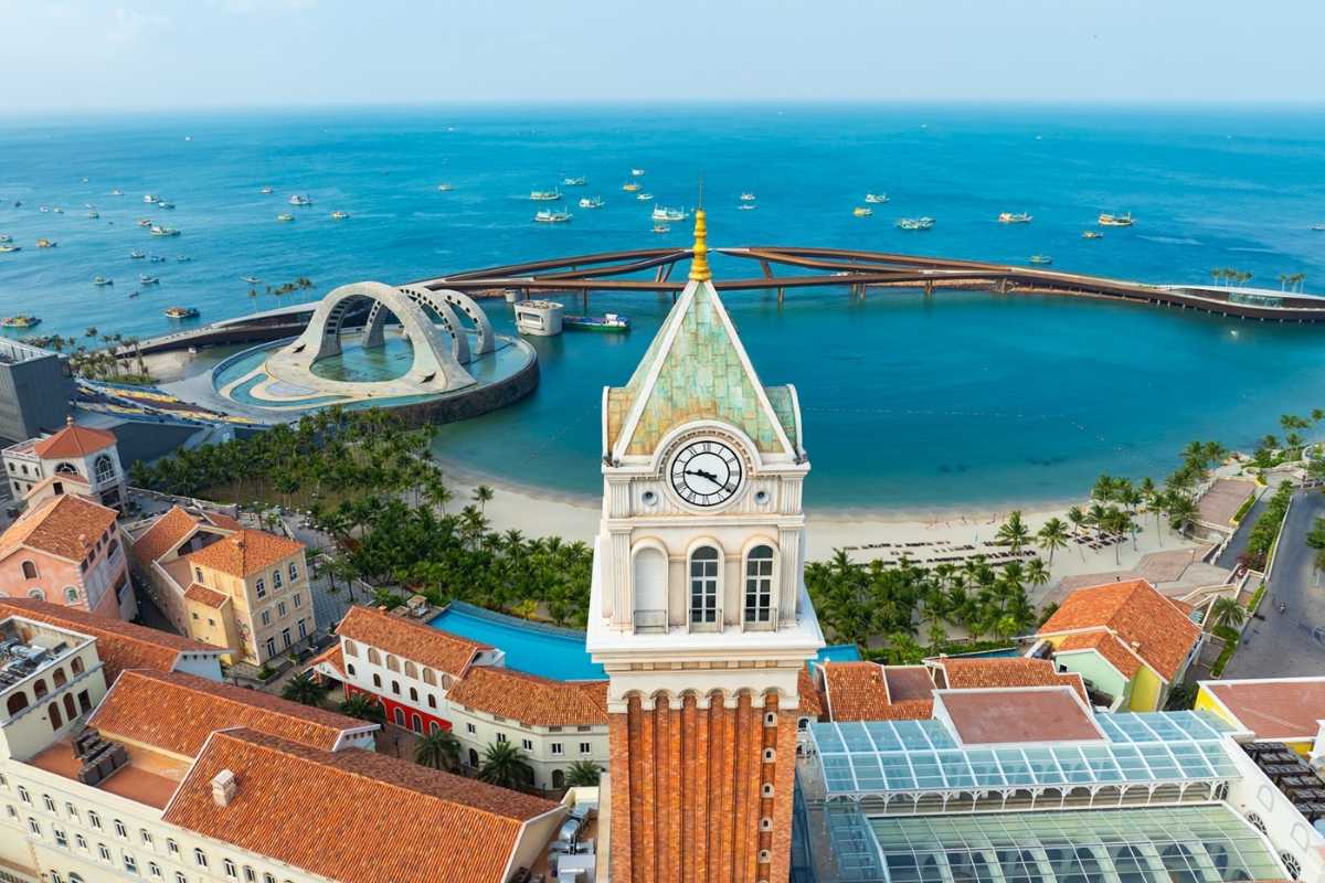 Close-up of Sunset Town Phu Quoc Clock Tower Close-up image of the iconic clock tower in Sunset Town Phu Quoc with beach and sea in background