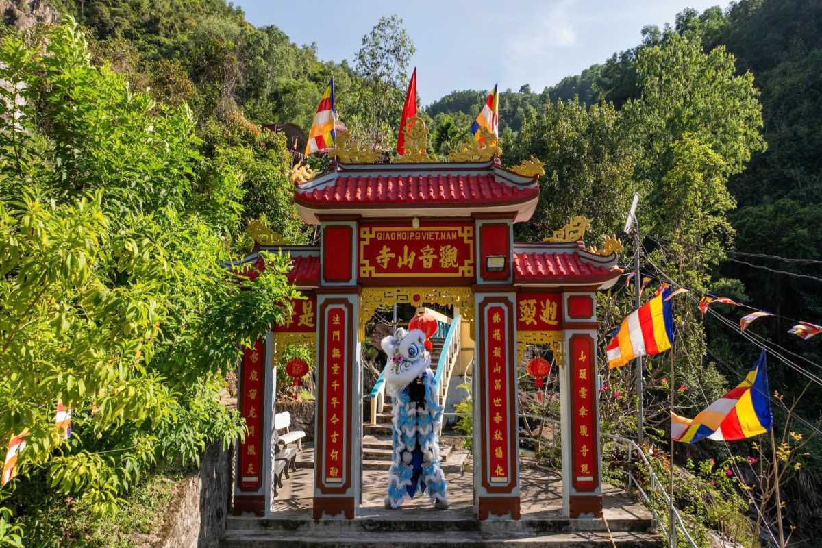 Entrance gate of Suoi Do Pagoda Nha Trang The vibrant red and gold entrance gate of Suoi Do Pagoda in Nha Trang decorated with colorful flags and traditional motifs