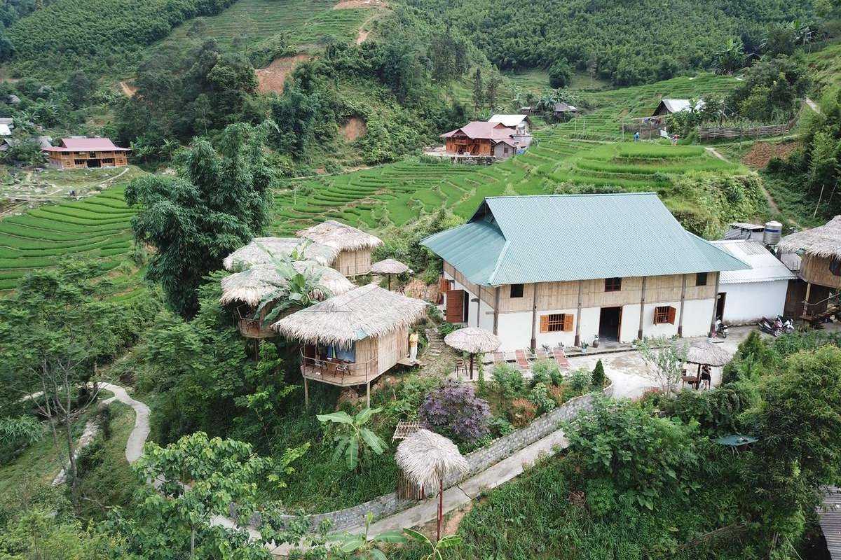 Ta Van Village Sapa Flowing River and Village Homes Ta Van Village Sapa showing a flowing river alongside traditional village homes and vibrant green landscape