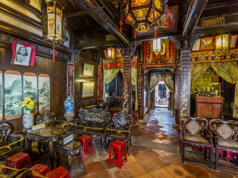 Interior view of Tan Ky Ancient House showcasing antique wooden furniture and traditional decor in Hoi An, Vietnam.