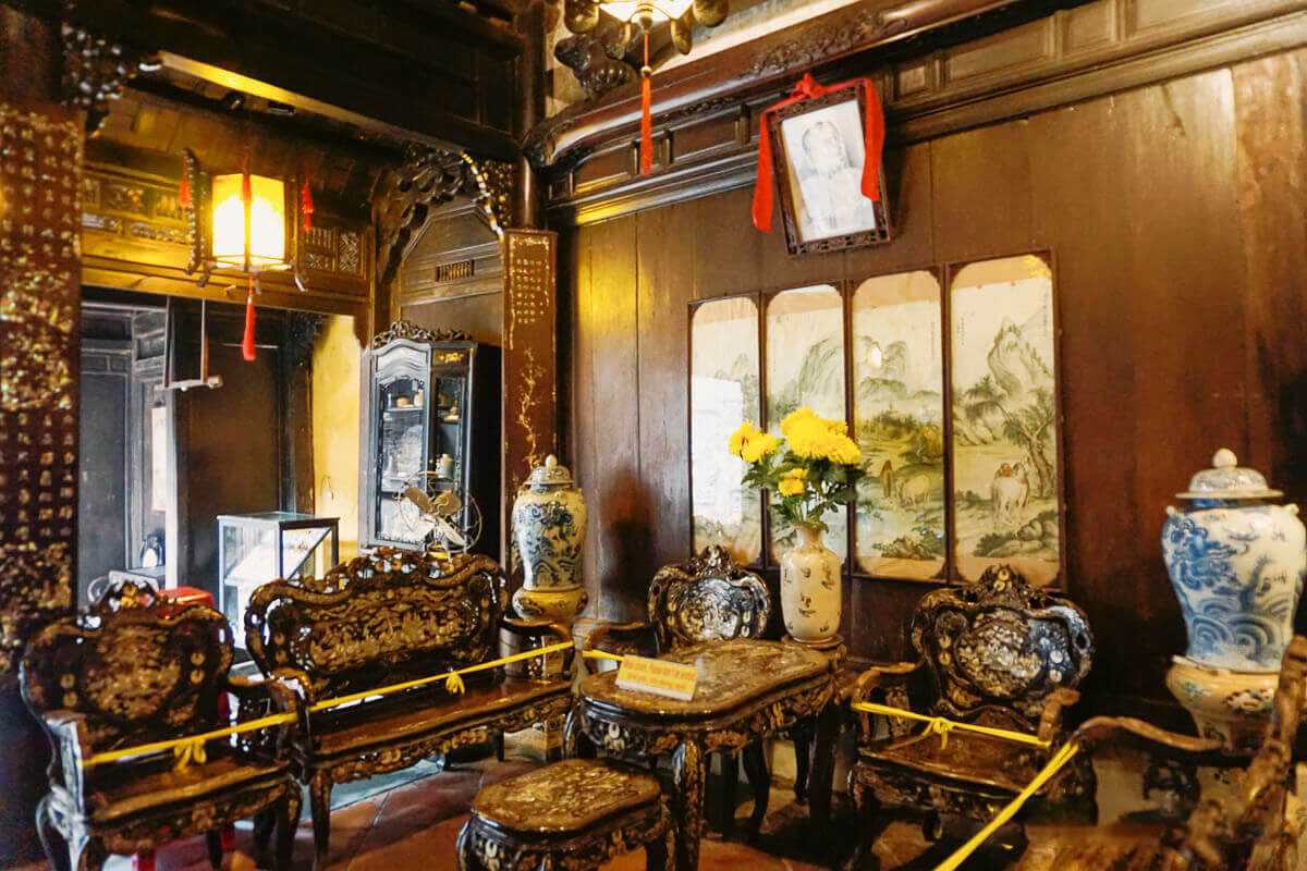 Traditional Seating Area in Tan Ky Ancient House Traditional seating area with carved wooden chairs inside Tan Ky Ancient House