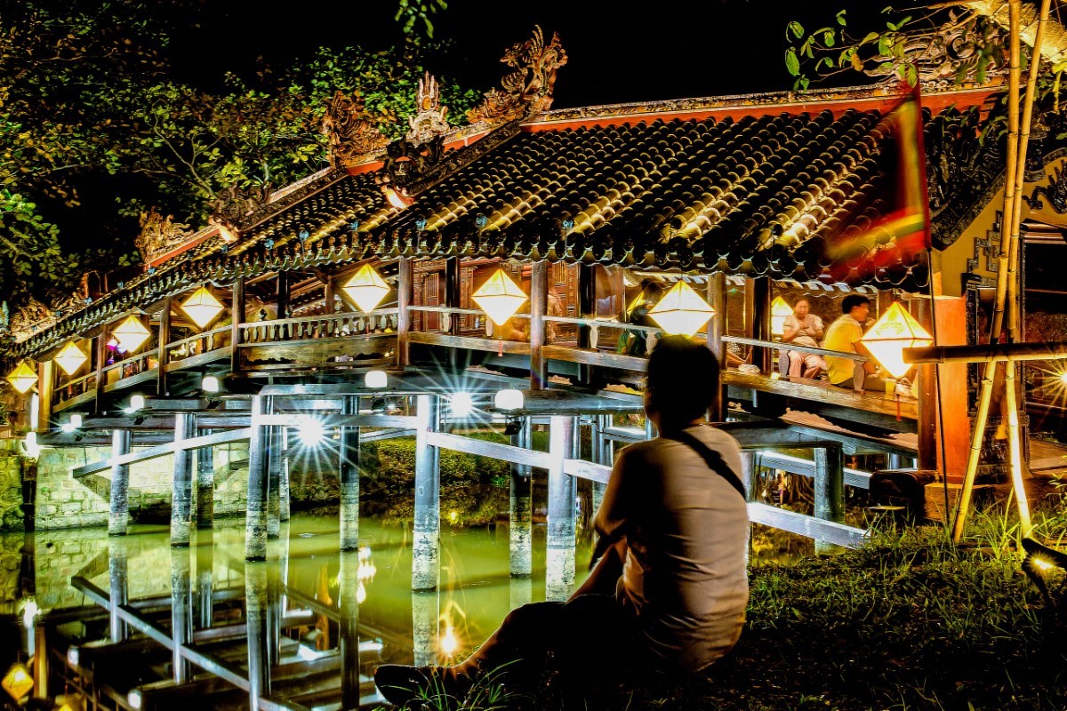 Thanh Toan Bridge in Hue illuminated by lanterns at night.