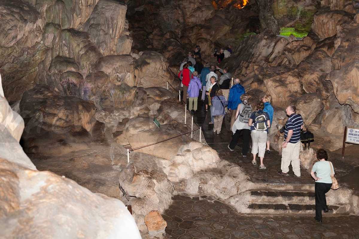 Thien Cung Cave Halong Bay visitor pathway and geological features Visitors exploring Thien Cung Cave Halong Bay along a paved pathway highlighting geological features