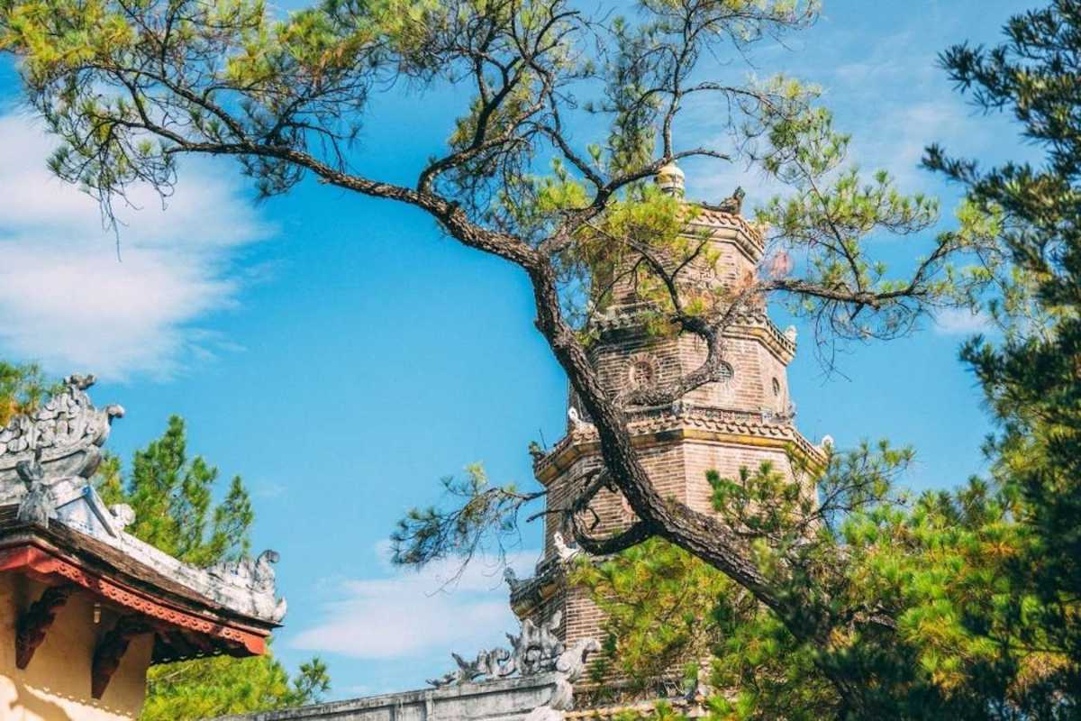 Visitors exploring the temple grounds of Thien Mu Pagoda in Hue Travelers explore the temple grounds of Thien Mu Pagoda, surrounded by heritage structures and natural scenery in Hue, Vietnam.