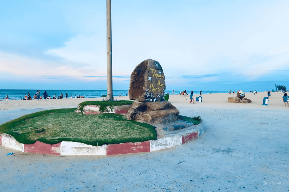 Thuan An Beach entrance with sunset view and beachgoers enjoying the serene environment.