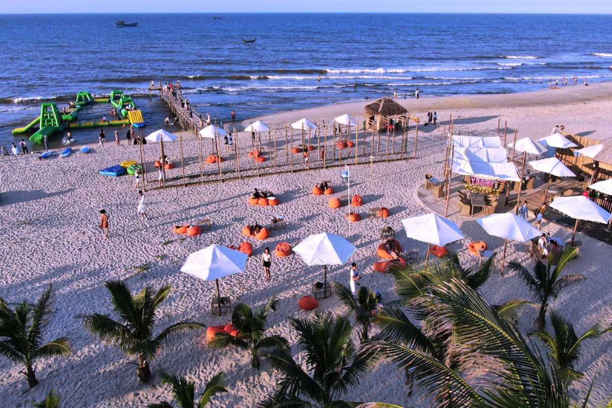 Thuan An Beach Hue beachside water park and outdoor activities Thuan An Beach Hue features inflatable water park attractions, beach games, and visitors under umbrellas, offering fun for families and groups.