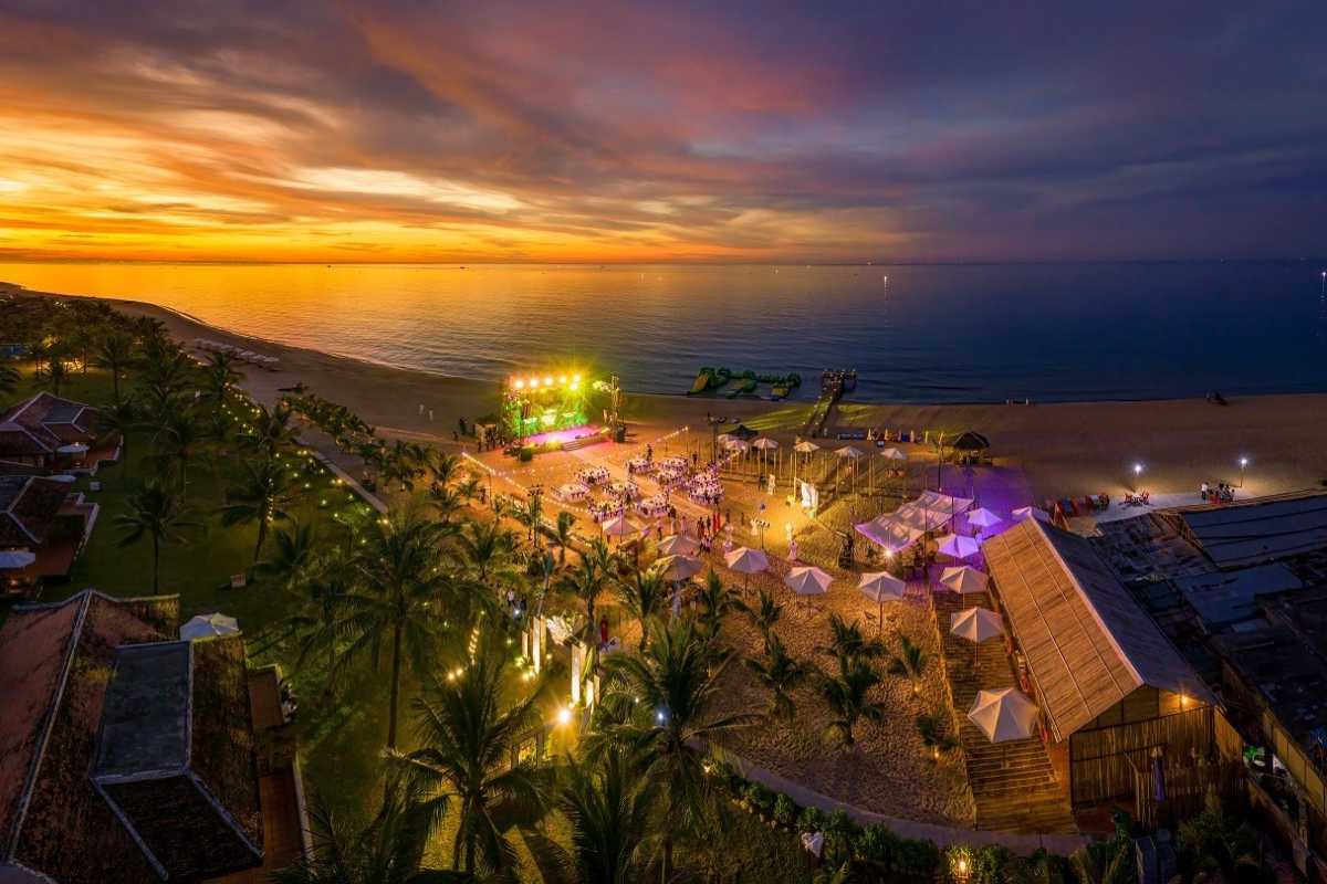 Thuan An Beach Hue illuminated evening event with palm trees Thuan An Beach Hue shines at night with a vibrant, illuminated event setup, palm trees, and a festive beachfront atmosphere perfect for gatherings.
