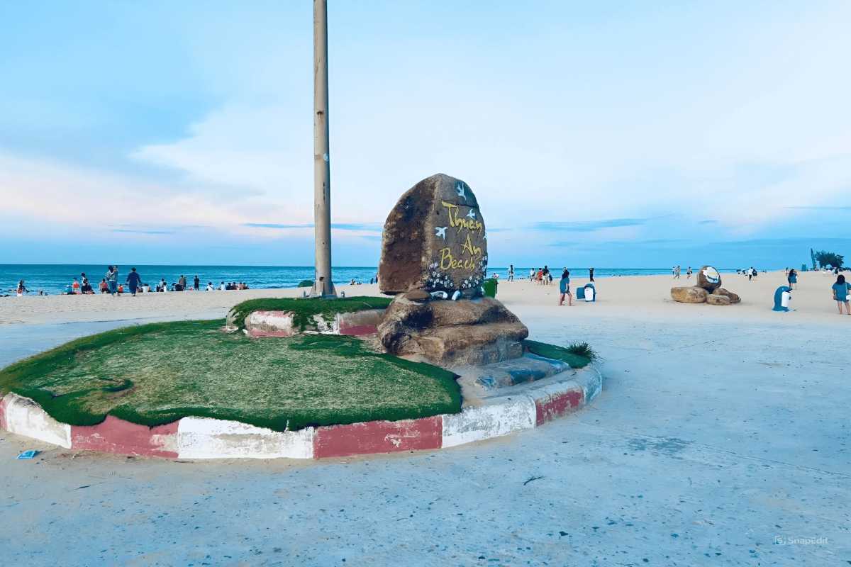 Thuan An Beach Hue main entrance landmark stone and families Thuan An Beach Hue main entrance features a large stone marker surrounded by families and groups enjoying the lively beach atmosphere.