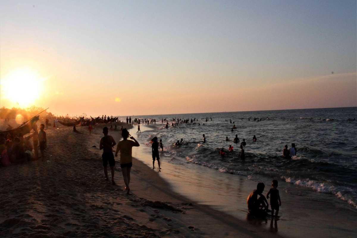 Thuan An Beach Hue sunset crowds enjoy the evening surf Thuan An Beach Hue is filled with families and friends swimming and relaxing in the surf as the sun sets, capturing the vibrant beach life.