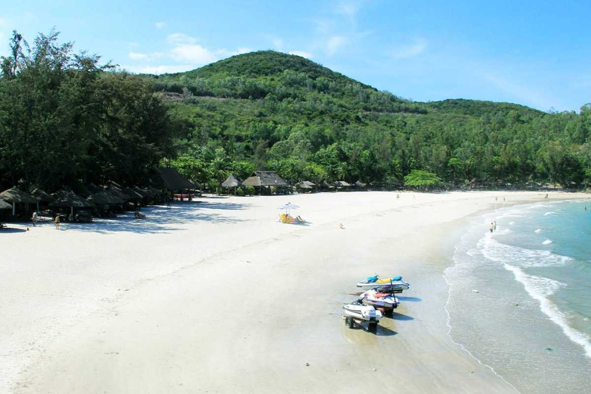 Tien Beach Nha Trang peaceful sandy beach and forest Peaceful sandy beach at Tien Beach Nha Trang backed by lush green forested hills and calm sea.