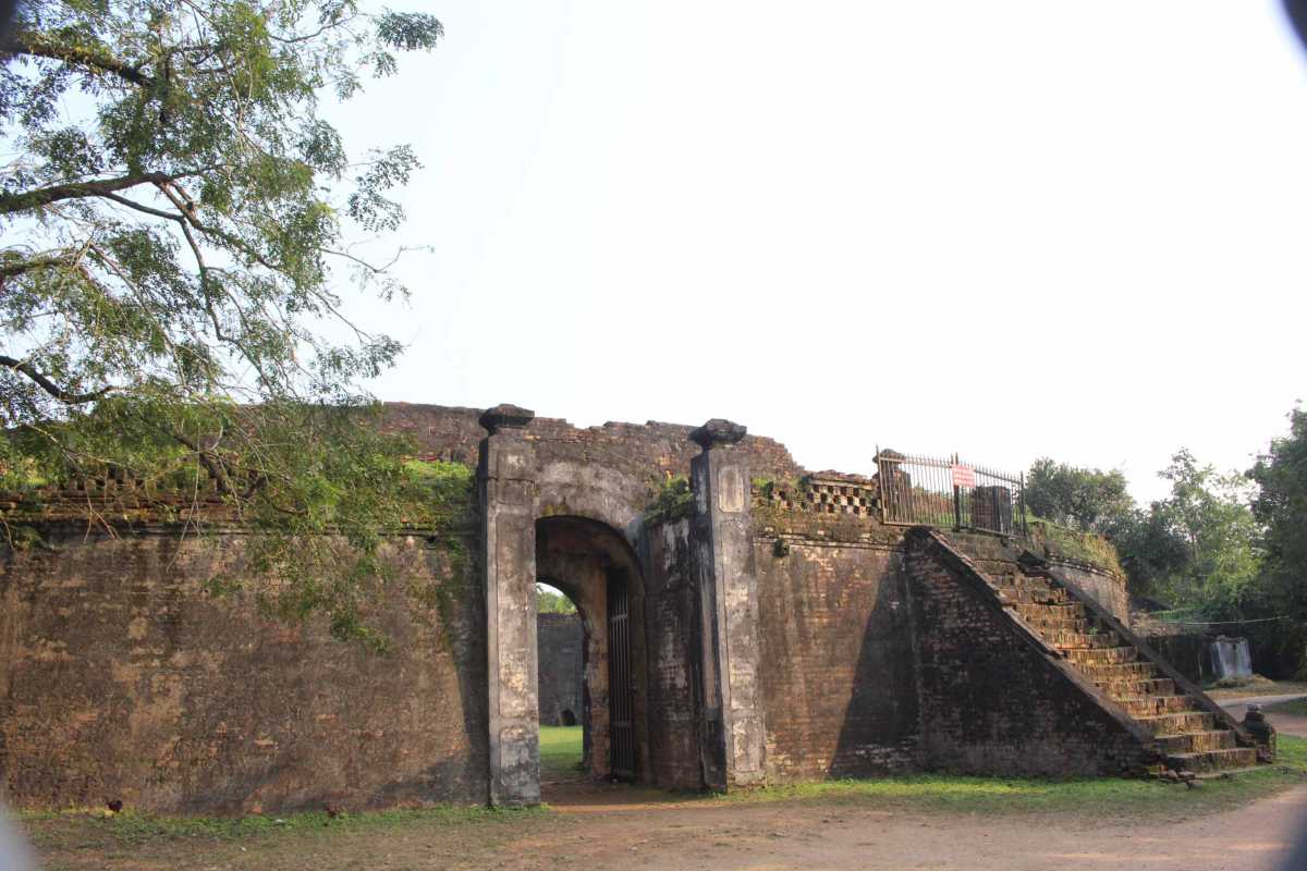 Tiger Arena Hue arched stone gate with flanking staircases Tiger Arena Hue’s arched stone gate sits between two historic staircases, surrounded by mature trees and ancient brick walls.