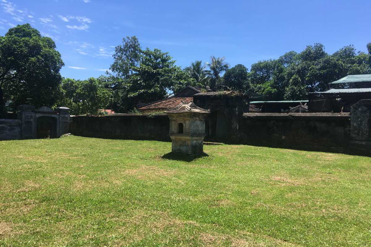 Tiger Arena Hue inner grass field with old stone altar Tiger Arena Hue features a peaceful inner grass field, highlighted by an ancient stone altar at its center, surrounded by high walls.