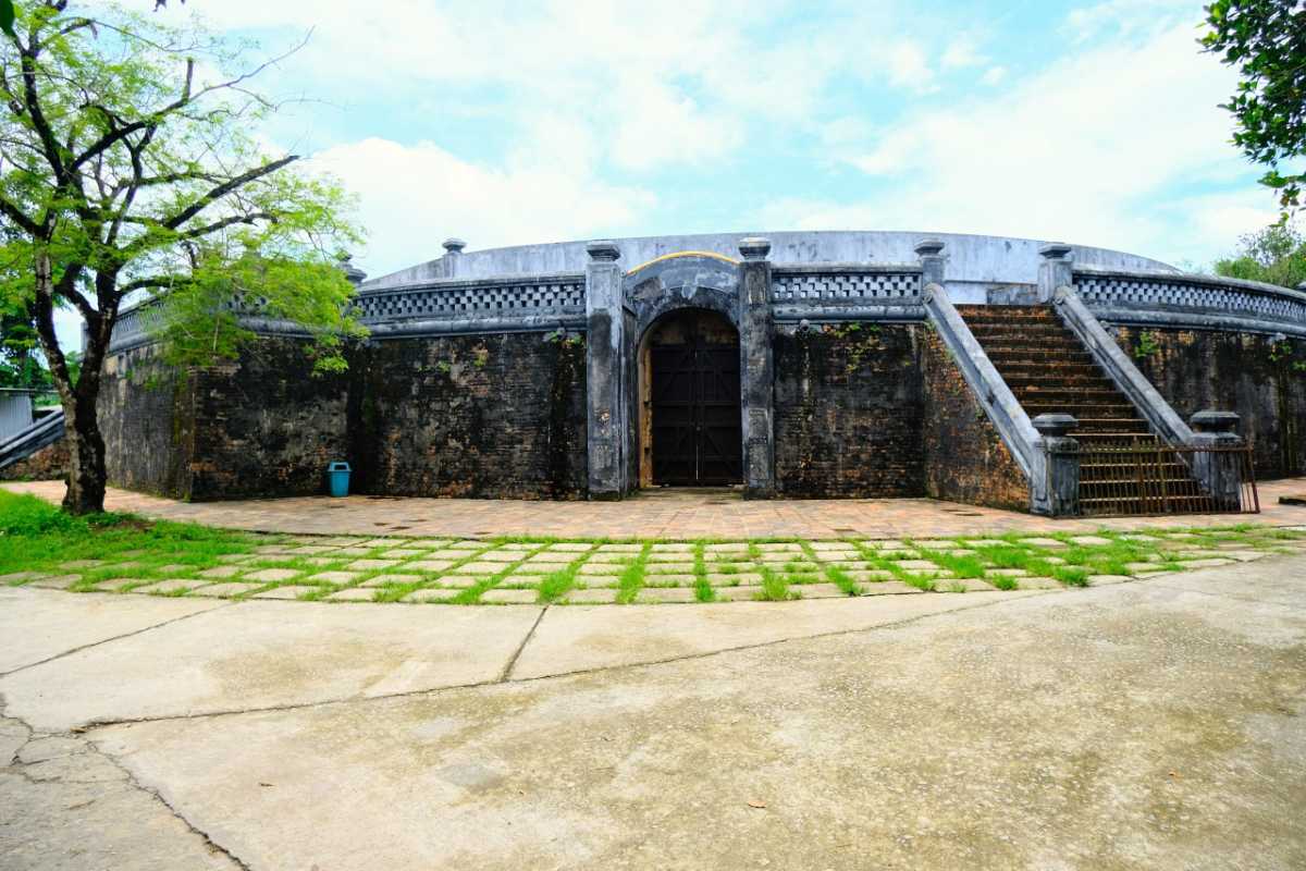 Tiger Arena Hue main gate and twin stairways under old trees Tiger Arena Hue displays its arched main entrance, twin stairways, and sturdy brick walls shaded by mature trees and open pathways.