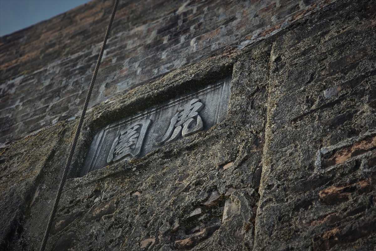 Tiger Arena Hue wall closeup with bold historic inscription Tiger Arena Hue wall features a bold, weathered stone inscription deeply set into the centuries-old brickwork for all visitors to see.
