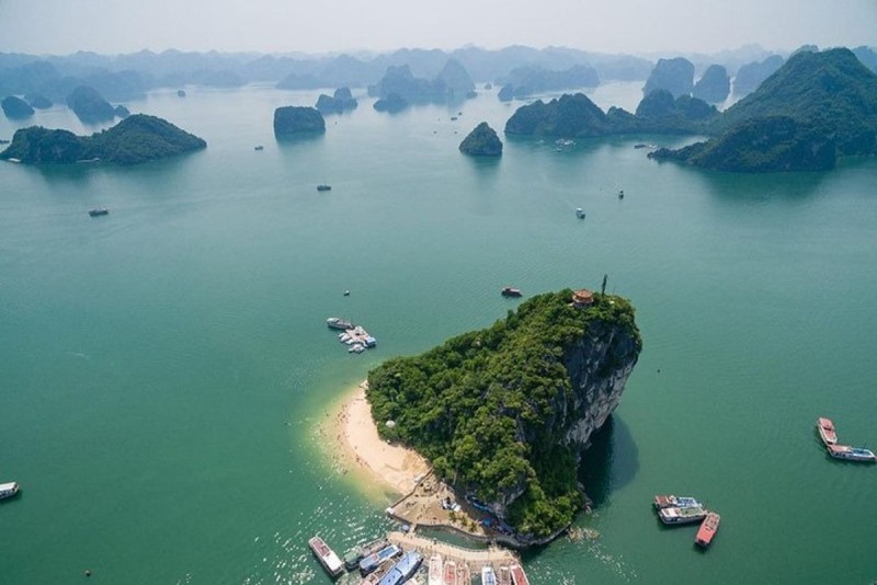 An aerial view of Titov Island in Halong Bay, with emerald green waters and surrounding limestone islands.