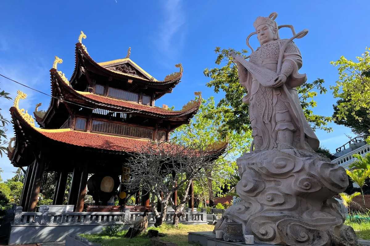 Tong Lam Lo Son Pagoda Pagoda Grounds and Statue White statue and traditional pagoda buildings surrounded by lush greenery at Tong Lam Lo Son Pagoda