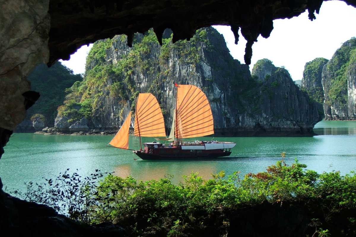 Tourist boats anchored near small beaches in Halong Bay Tourist boats anchored near secluded beaches close to Drum Cave Halong Bay, perfect for relaxing stops.