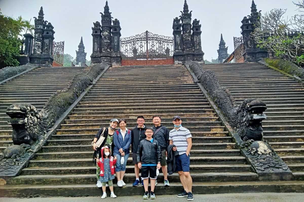 Visitors on dragon staircase at Khai Dinh Tomb Group of visitors posing on the main staircase with dragon sculptures at Khai Dinh Tomb in Hue