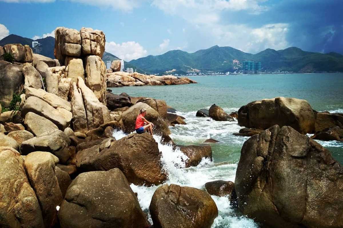 Tourists exploring rocky shore at Hon Chong Promontory Visitors walking and sitting on rocks at Hon Chong Promontory in Nha Trang