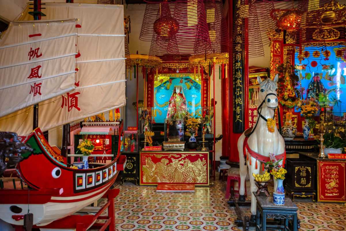 Traditional Boat and Altar Inside Cantonese Assembly Hall Traditional red boat and colorful altar decorations inside Cantonese Assembly Hall Hoi An