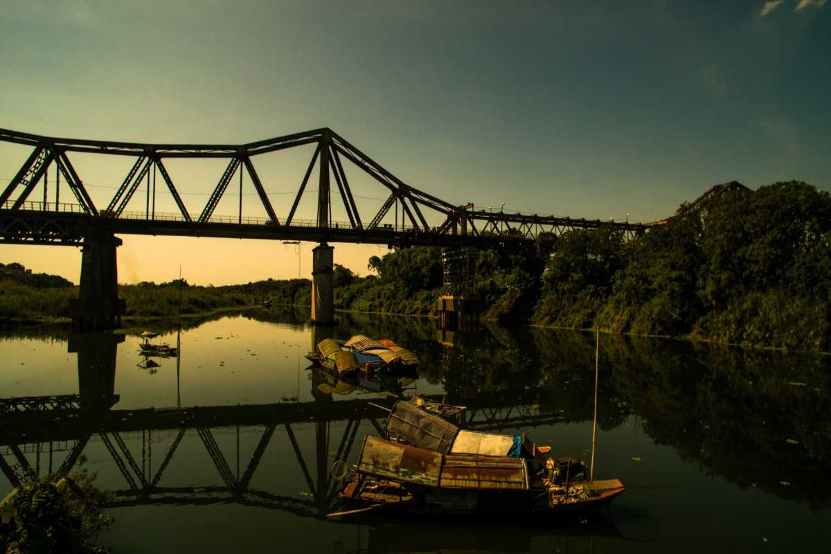 Traditional Boats Near Long Bien Bridge Traditional boats floating on calm water beneath Long Bien Bridge in Hanoi