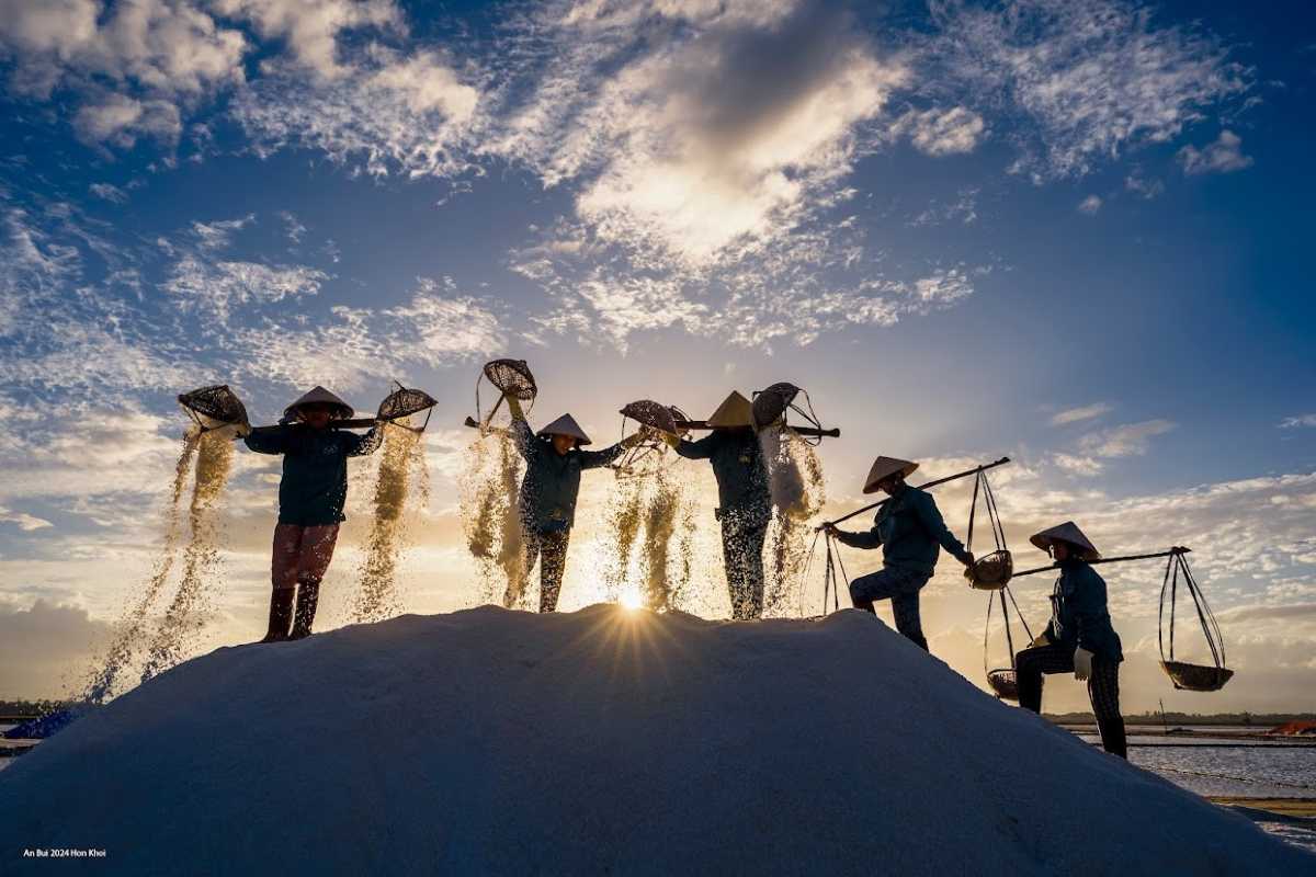 Traditional Salt Harvesting Team at Dam Vua Group of farmers working together to harvest salt with traditional baskets at Dam Vua
