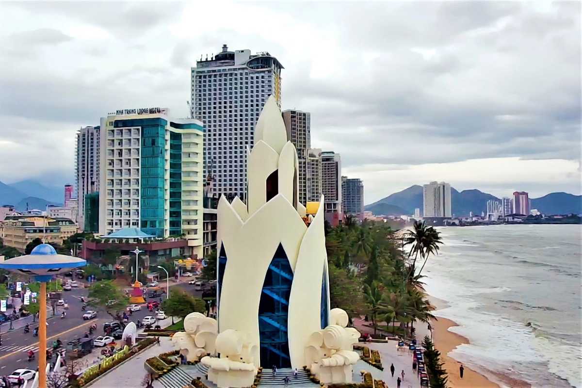 Tram Huong Tower with skyline and beach Tram Huong Tower from the side, set against the ocean and downtown skyline on a cloudy day