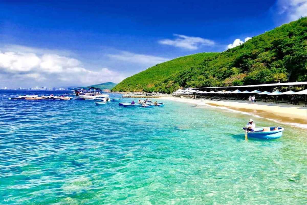 Tranh Beach Nha Trang Clear Water View Clear turquoise waters and sandy shore at Tranh Beach Nha Trang with lush greenery in the background