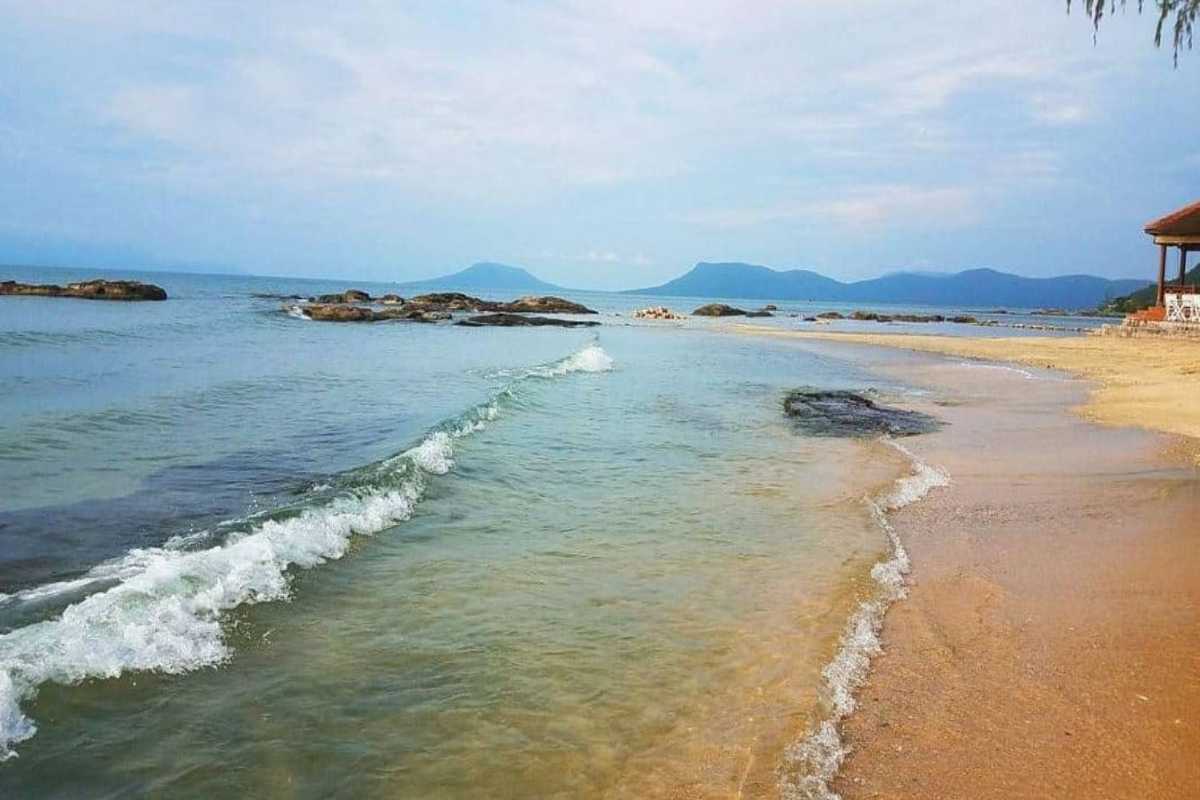 Tranquil Beach at Ganh Dau Cape The quiet beach of Ganh Dau Cape, featuring gentle waves and soft golden sands.