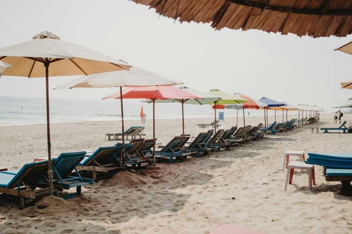 Tropical Beachside Restaurant at An Bang Beach Wooden restaurant with thatched roof and palm trees overlooking sandy beach and ocean