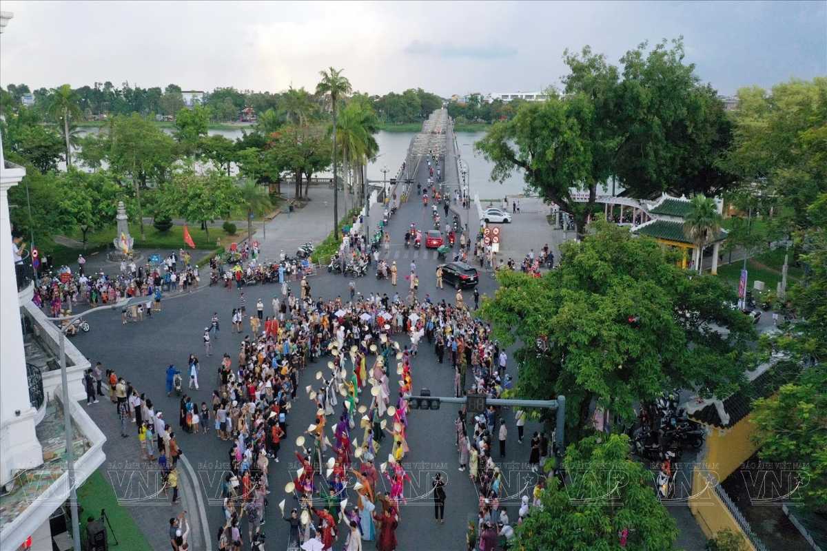 Truong Tien Bridge Festival Crowd in Hue Large crowd gathered near Truong Tien Bridge in Hue during a cultural parade and festival.