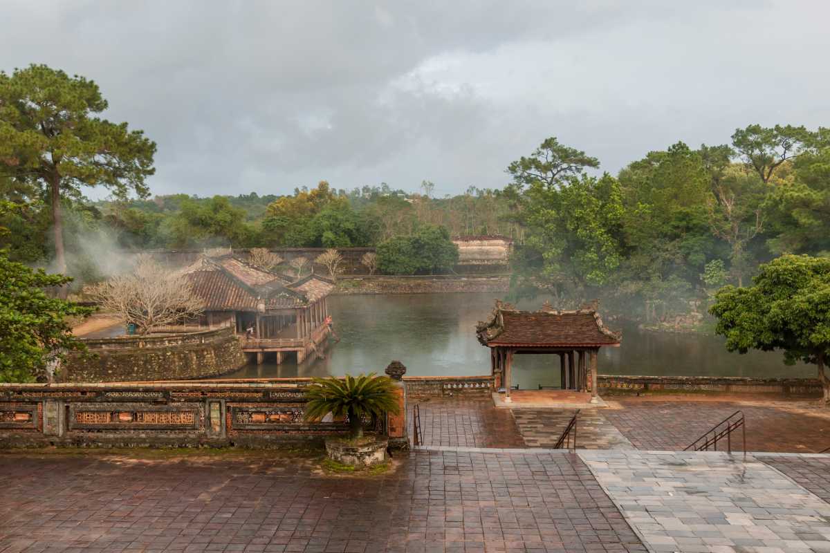 Misty Morning at Tu Duc Tomb Entrance Gate Entrance gate of Tu Duc Tomb shrouded in morning mist with lush greenery around