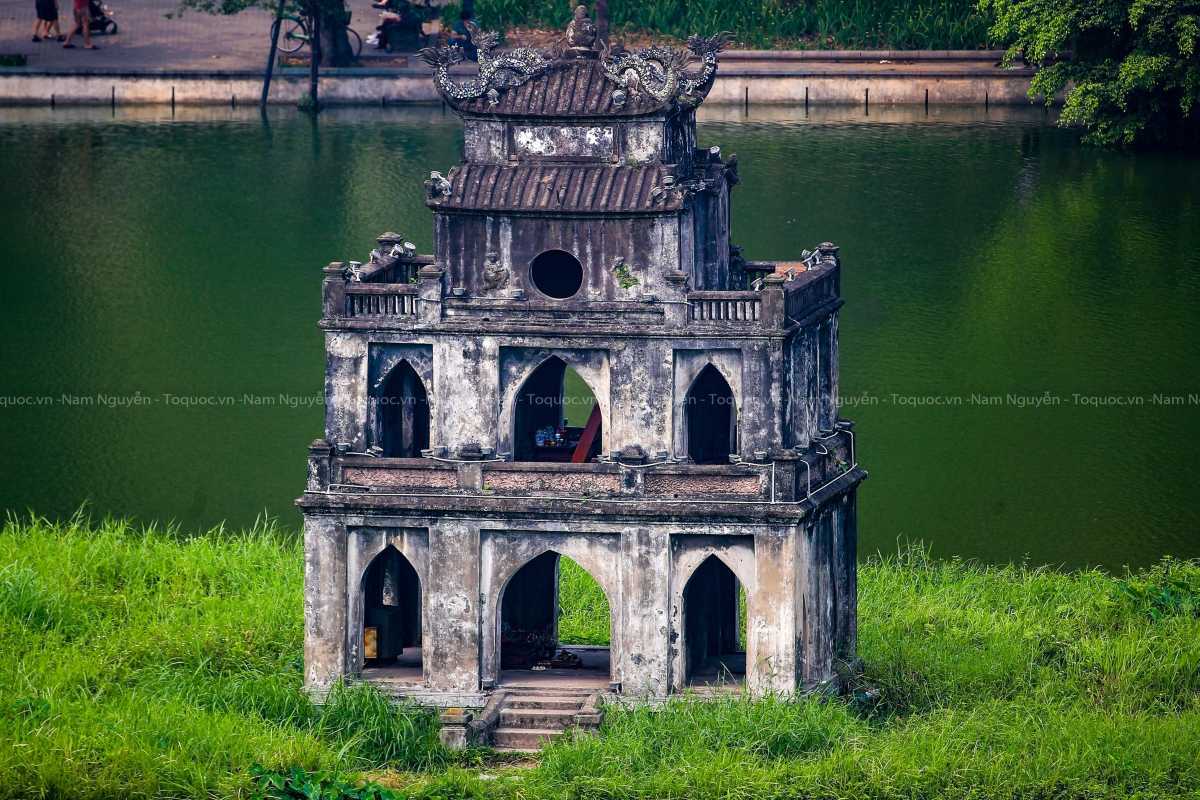 Turtle Tower Hanoi Historic Lakeside View View of the historic Turtle Tower in the center of Hoan Kiem Lake Hanoi with surrounding greenery