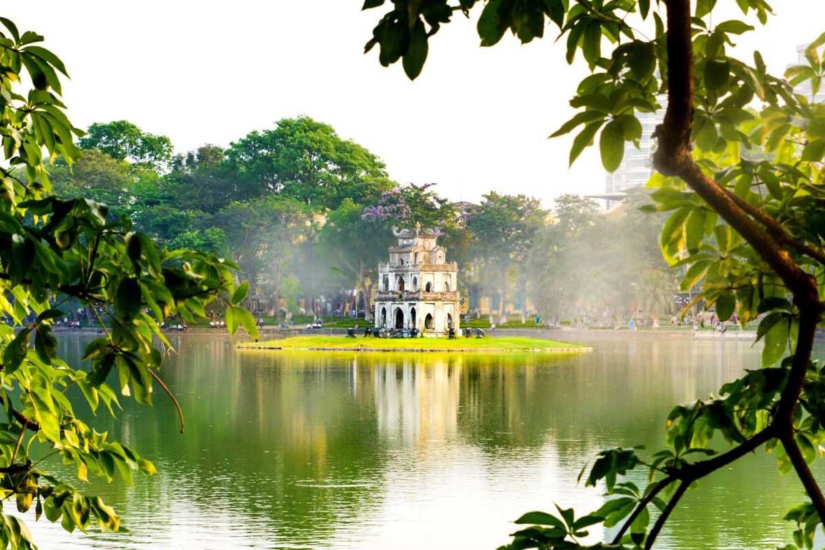 Turtle Tower with Blooming Trees Around Turtle Tower surrounded by lush greenery and vibrant flowering trees at Hoan Kiem Lake