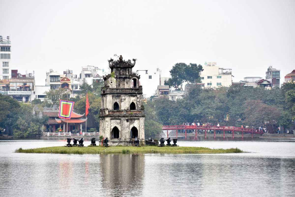 Turtle Tower with City Reflections in Water Turtle Tower reflected in calm waters with Hanoi’s city lights in the evening
