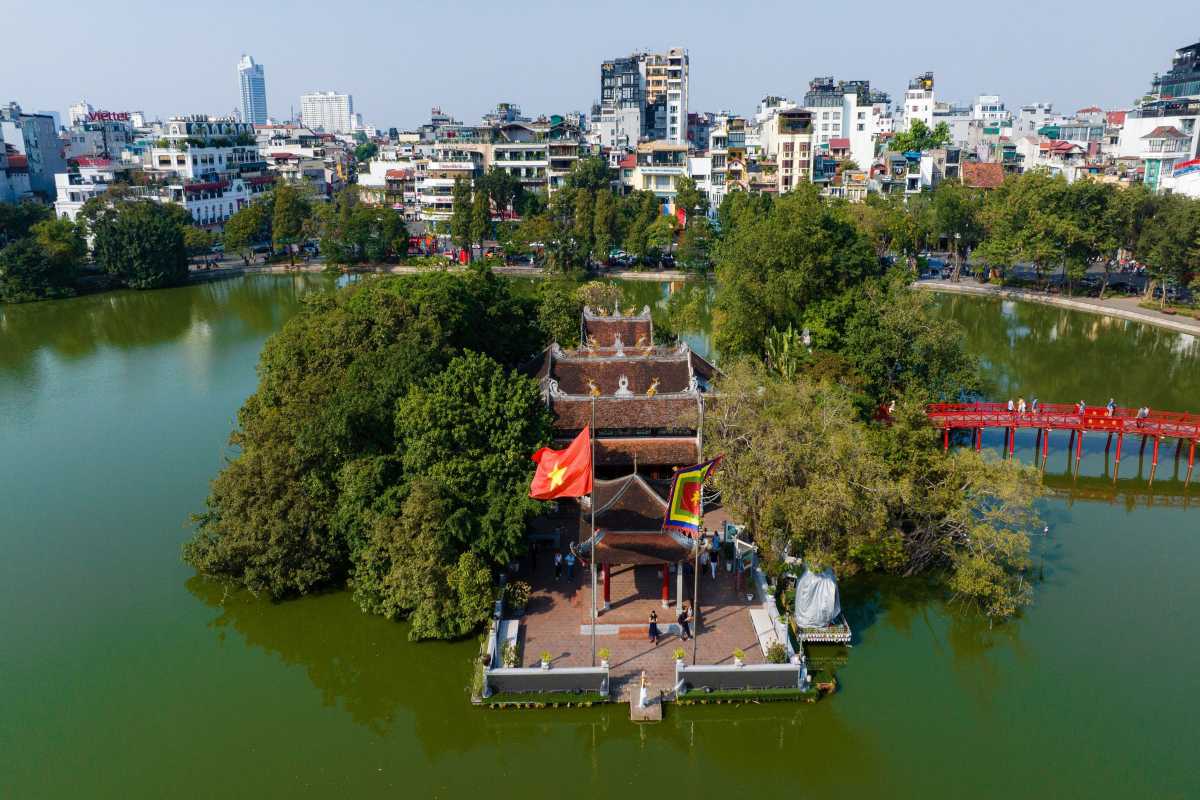 Turtle Tower with VNPT Hanoi Building Background Turtle Tower with VNPT Hanoi building visible in the background, framed by trees