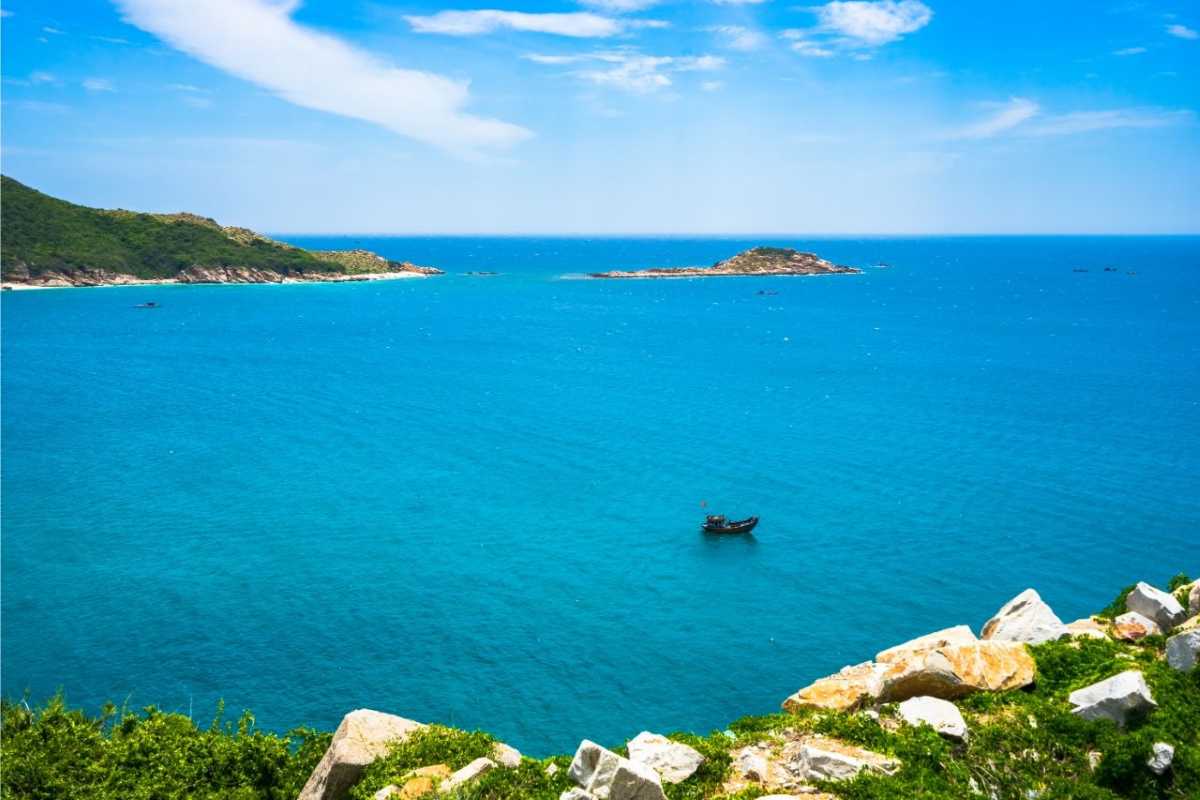 Wide blue sea with distant islands off Van Phong Bay View of open ocean with small forested islands and blue water from Van Phong Bay cliffs