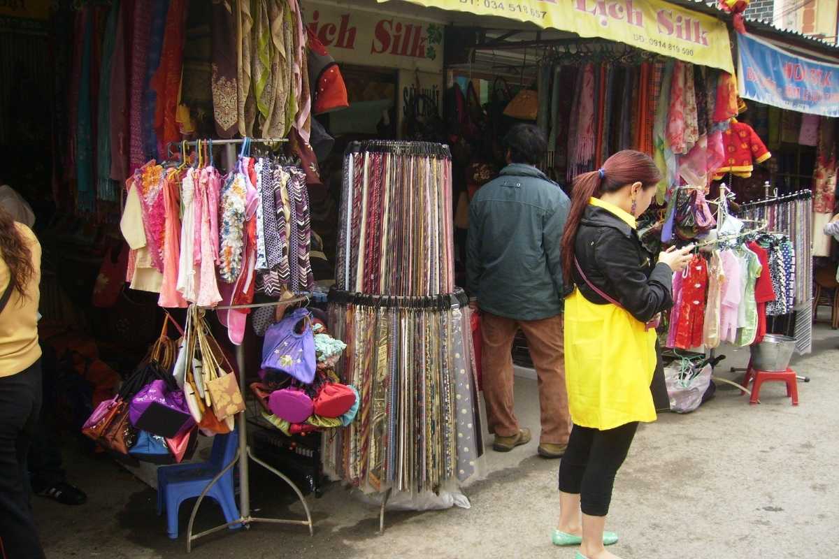 Van Phuc Silk Village Market Entrance Traditional market entrance at Van Phuc Silk Village with silk banners and visitors entering.