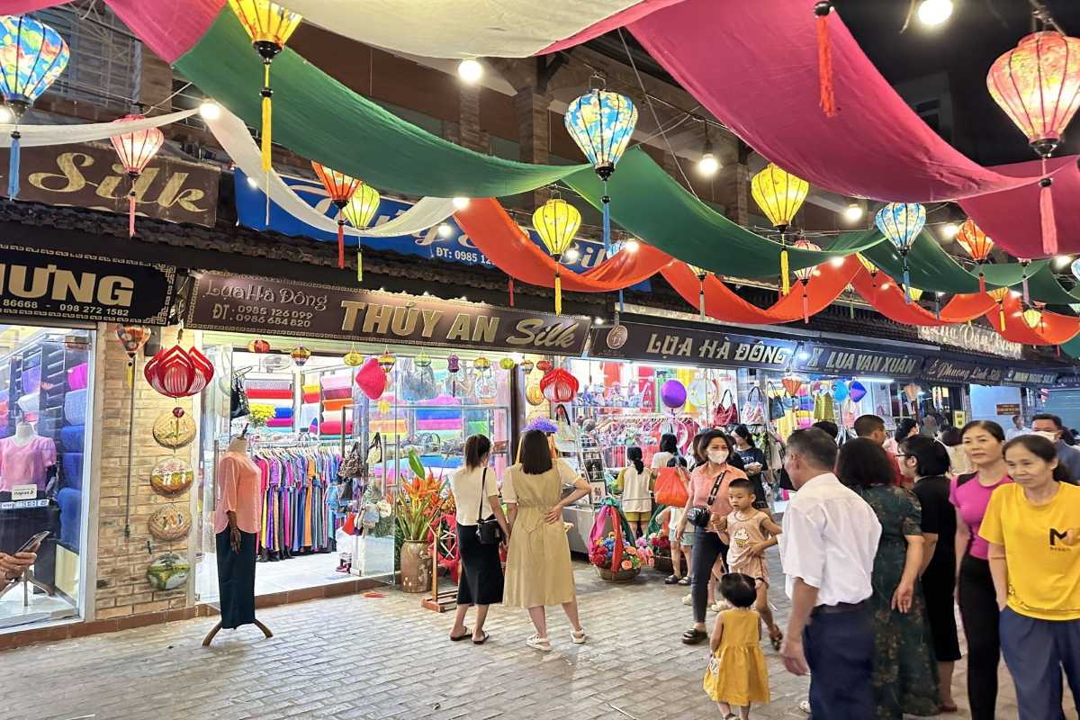 Van Phuc Silk Village Silk Fashion Shopping Customers selecting silk garments inside a shop at Van Phuc Silk Village, featuring traditional styles.
