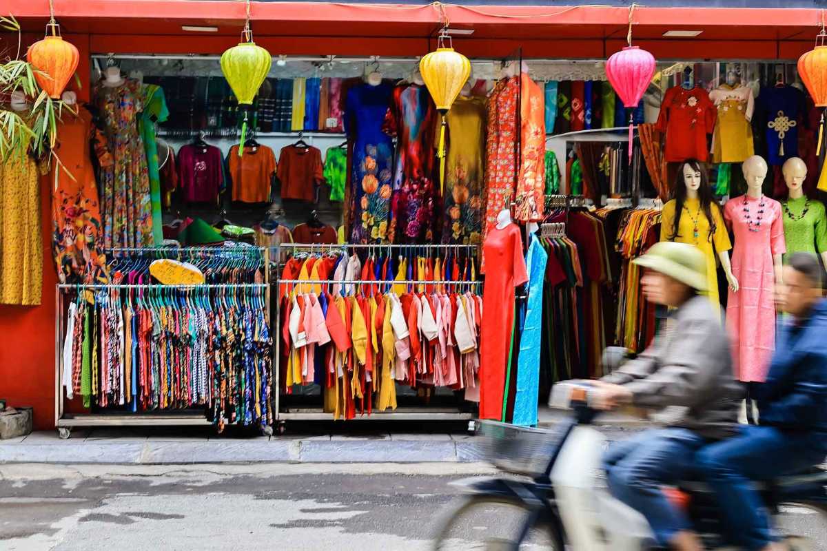 Van Phuc Silk Village Silk Vendor Smiling Friendly silk vendor smiling and showcasing silk scarves at Van Phuc Silk Village market.