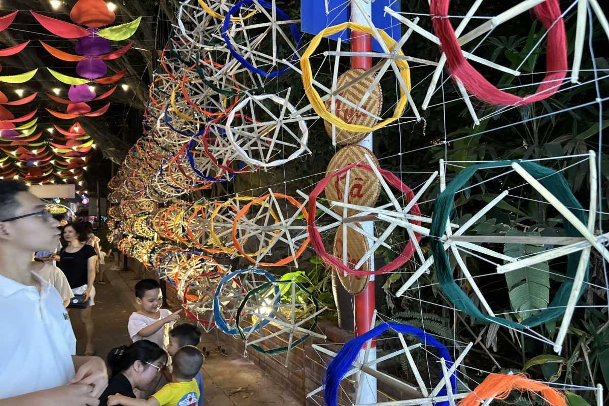 Van Phuc Silk Village Umbrella Street Market Scene Market scene with visitors and umbrellas overhead at Van Phuc Silk Village vibrant silk market street.