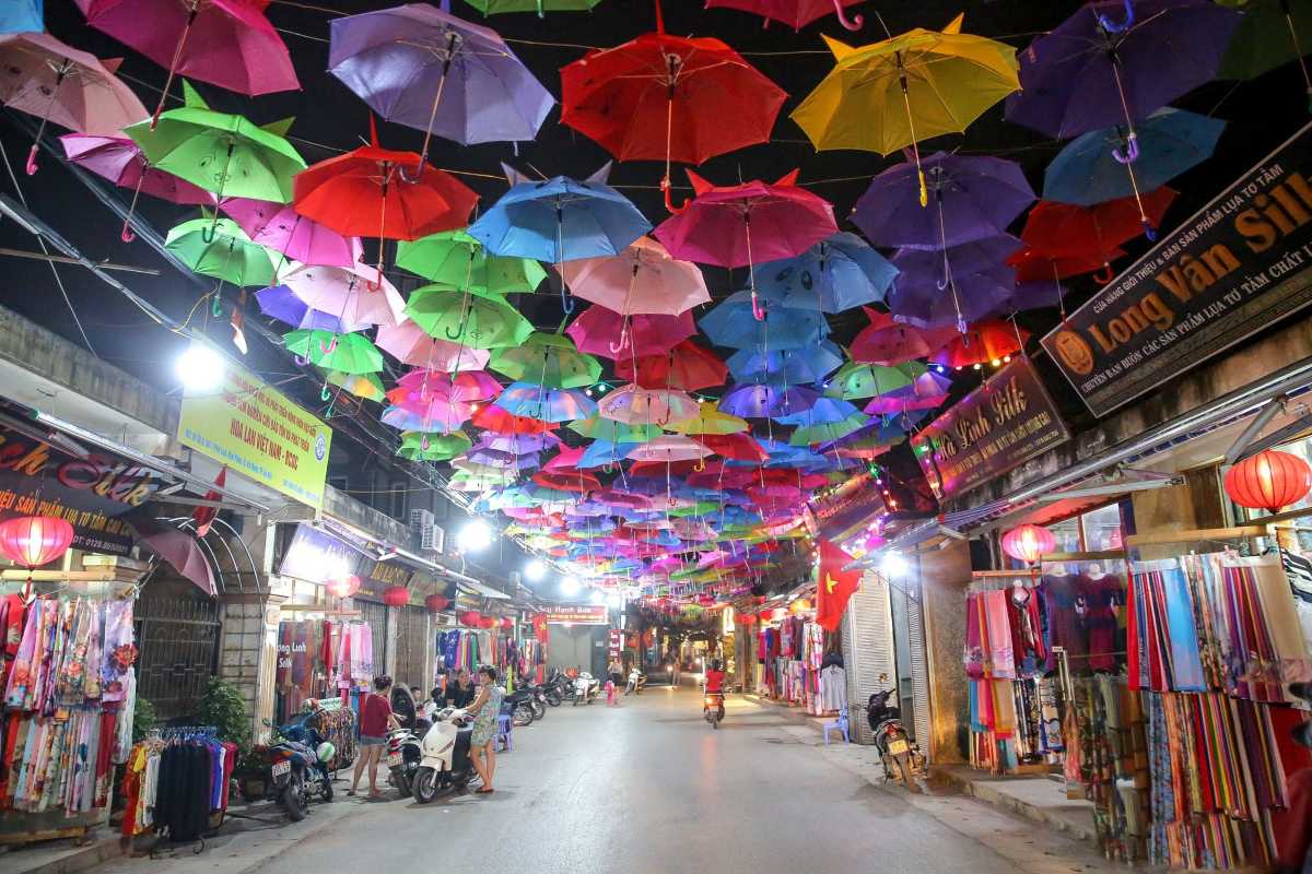 Van Phuc Silk Village Visitor with Lanterns Tourist at Van Phuc Silk Village under colorful lanterns, exploring traditional silk weaving culture.