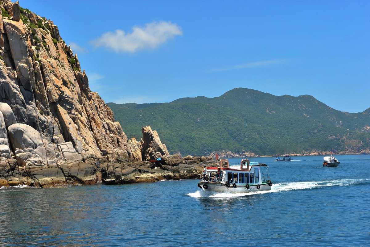 Vinh Hy Bay Boats and Mountains Small fishing boats anchored in bay waters with green mountainous backdrop at Vinh Hy Bay